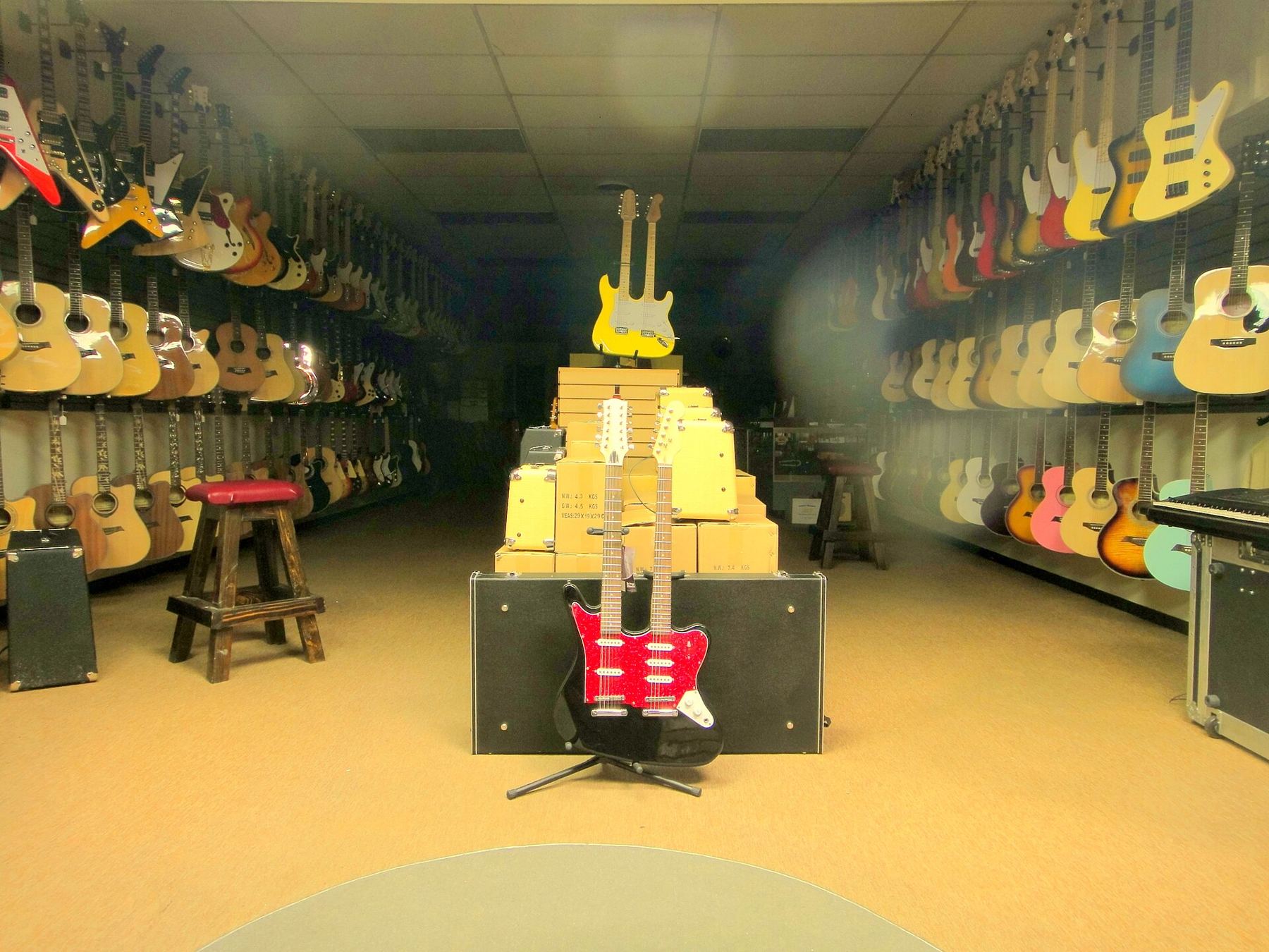 A long music store aisle lined with guitars on both walls
