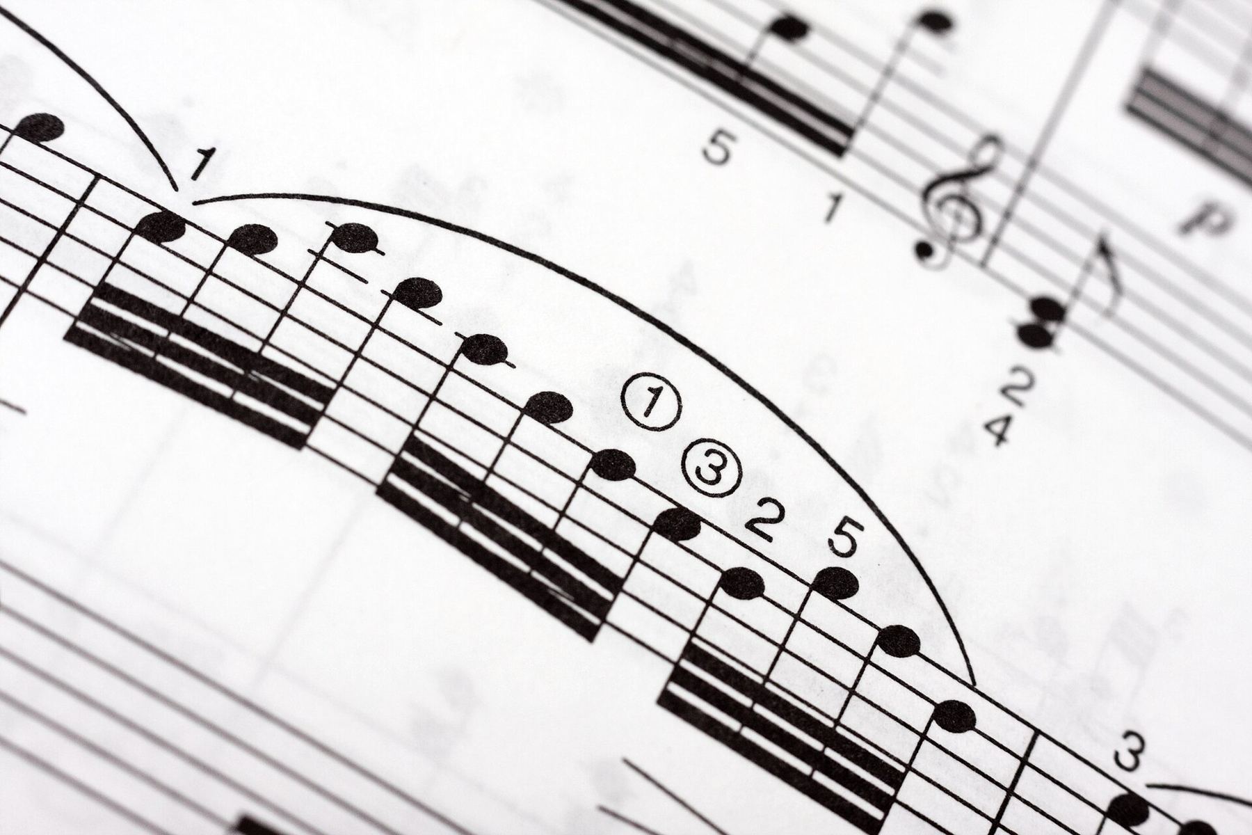 Close-up of printed sheet music with fingering numbers