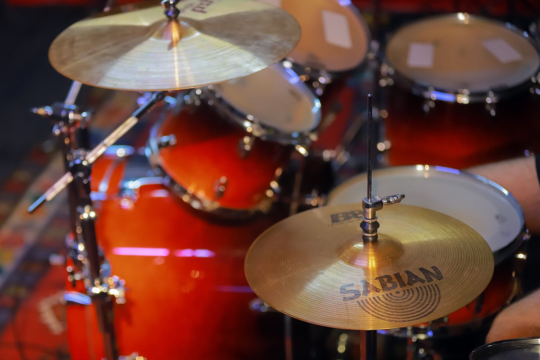 A red sparkle drum kit with brass cymbals in close-up