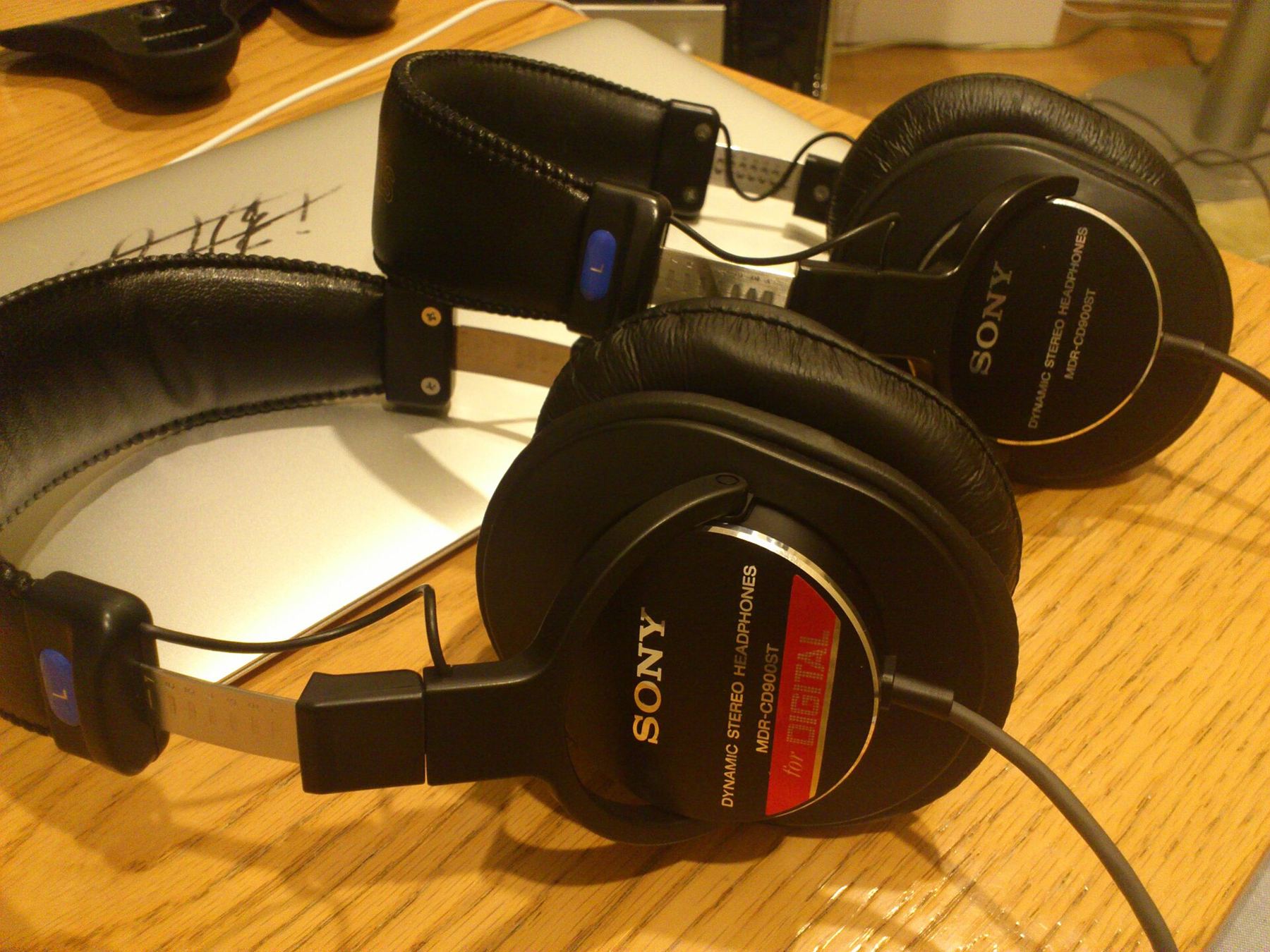 Two pairs of closed-back studio headphones resting on a desk