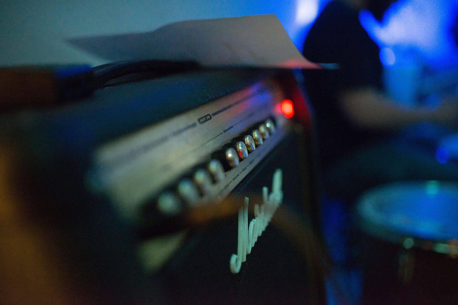 A guitar amplifier glowing under blue stage light