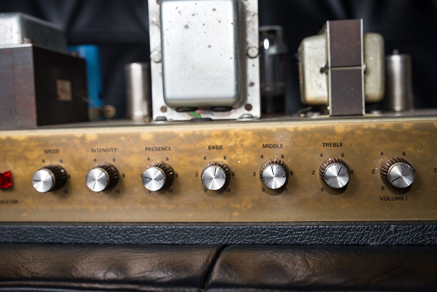 The control panel of a vintage amplifier with brass-coloured knobs